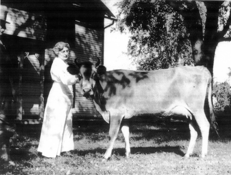 Edward (standing at left) and Elinor with a highly regarded animal.  In the front yard at Woodside in 1918.