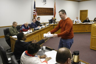Resident Brandon Jones turns in a stack of petitions opposed the the change.