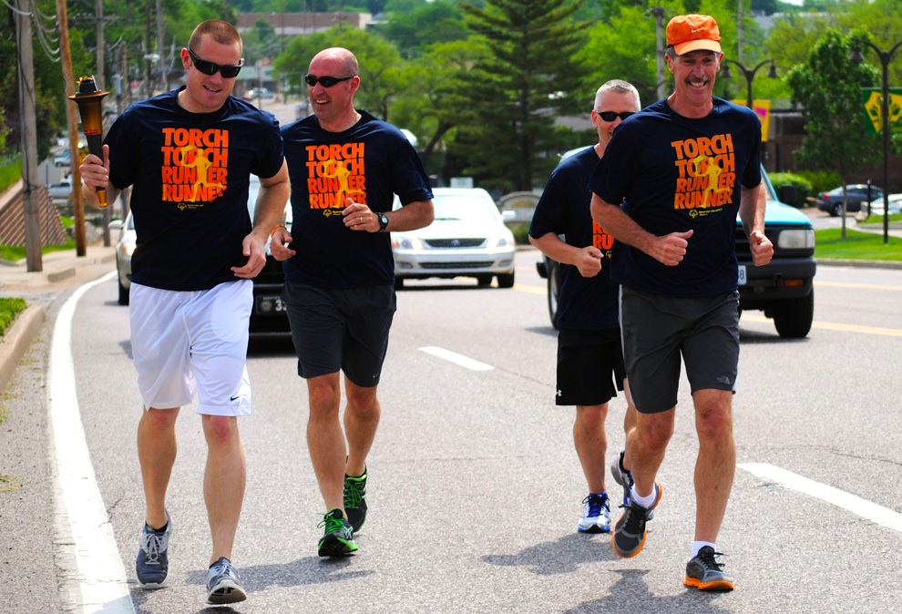 Brentwood Police officers carry Special Olympics Torch past St. Mary Magdalen