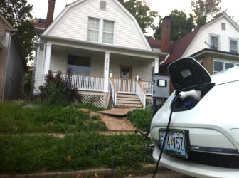 Andrew Bolin's Nissan Leaf charges in front of his house, with 10 solar panels on the roof.