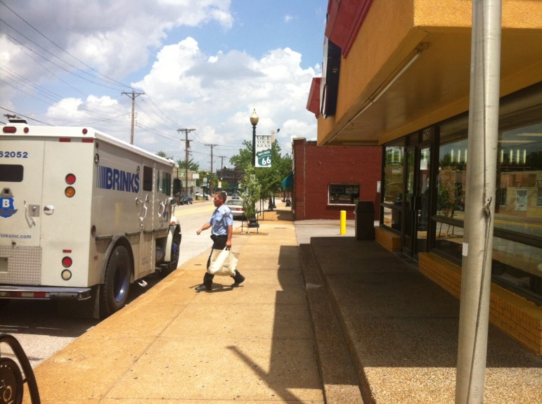 A Brinks armored truck drivers removes the proceeds from the closed Church's Chicken.
