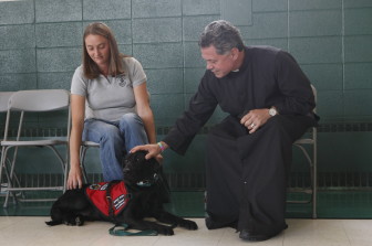 Father Jack Siefert with his service dog, Francis, and trainer, Erin Coulter.