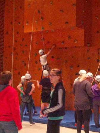 Students climb the rock wall at The College School as part of a day long experiential discussion on race and rights.