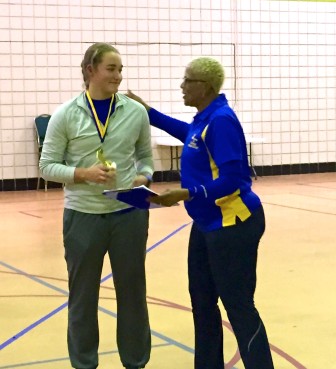 Myrle Mensey, director of the Throwing and Growing foundation presents Sophia Rivera with first place in shot put.