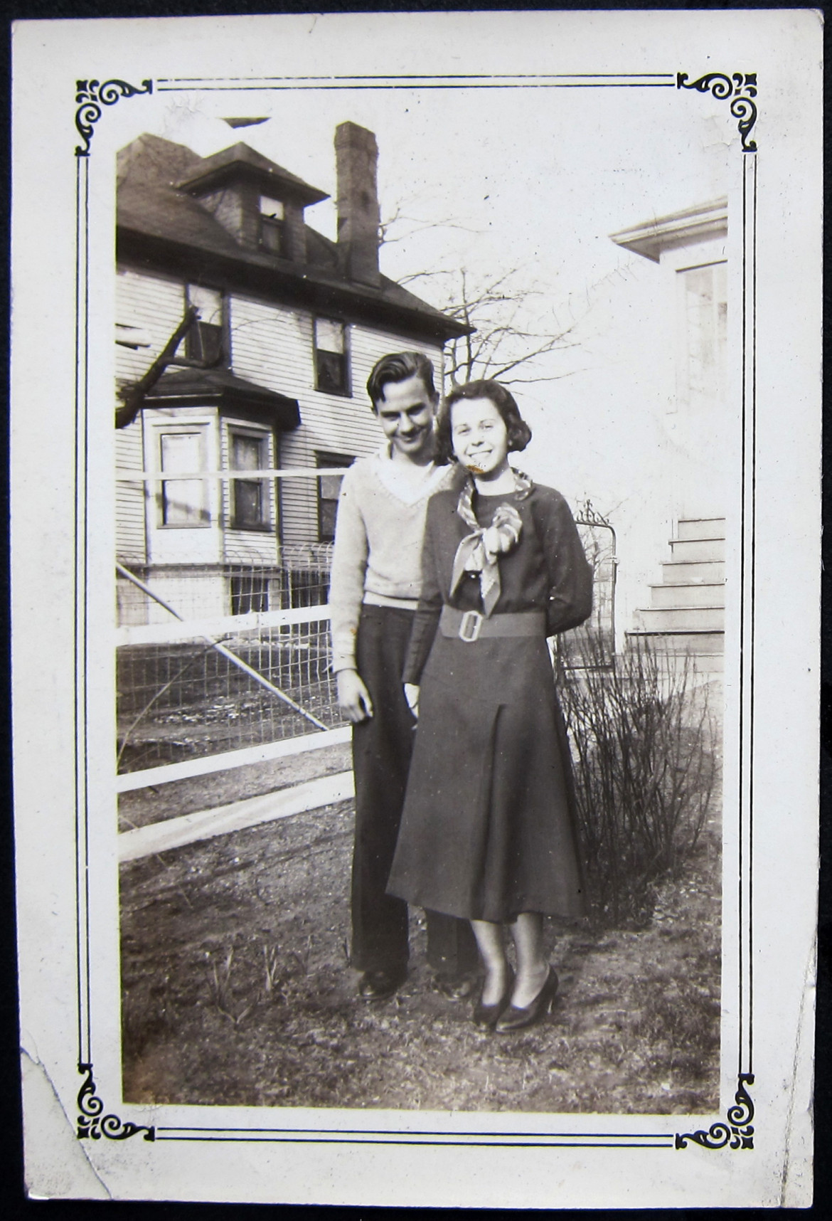 Marjorie with an unidentified friend with the neighbor's home in the rear.