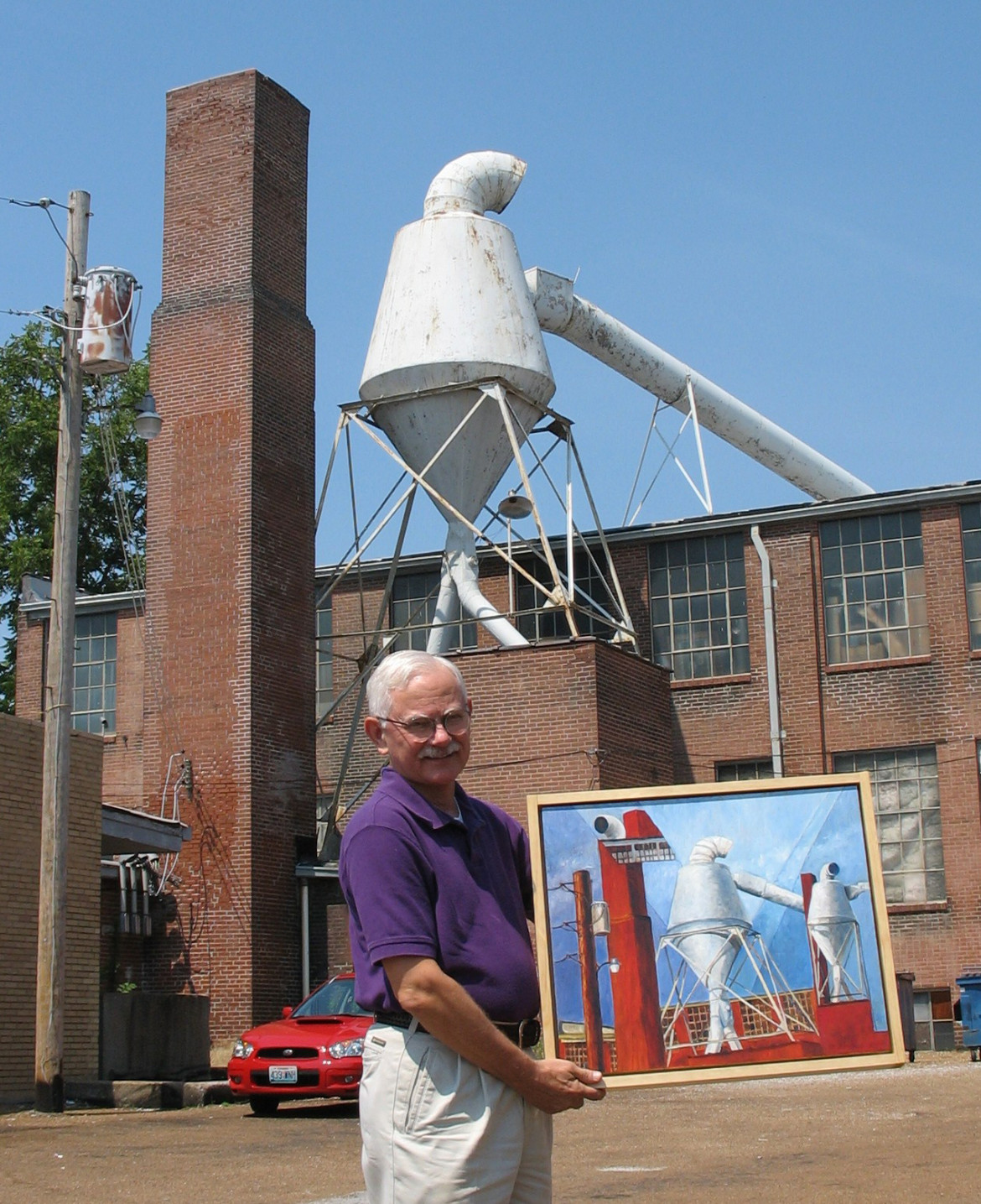 Artist Steve Turner displaying his prize winning photo of the Maplewood Cyclone in front of the same.