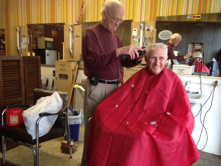 Barber Stan Chenoweth gives one of his last haircuts to James Summers.
