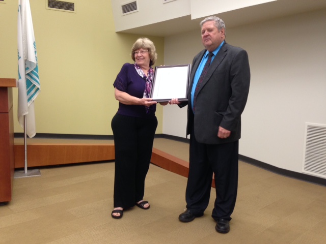 Bonnie Paulsmeyer accepts a proclamation for the Kiwanis Club from Maplewood Mayor Jim White.