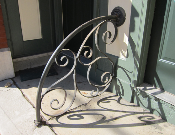 A great little wrought iron railing between the two doors to the upstairs apartments.