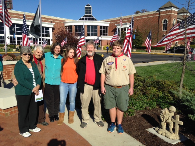 Tyler Phipps (right), Boy Scout who oversaw constructing the foundations for two statues at the Mid-County Veterans Memorial, with his family at the memorial on Sunday. The project was for his Eagle Scout award, which he hopes to receive in December.