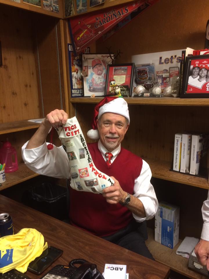 Jerry Gibbs, owner of J&E Office City, with it present from Santa Friday night at the Maplewood Christmas Tree Walk.